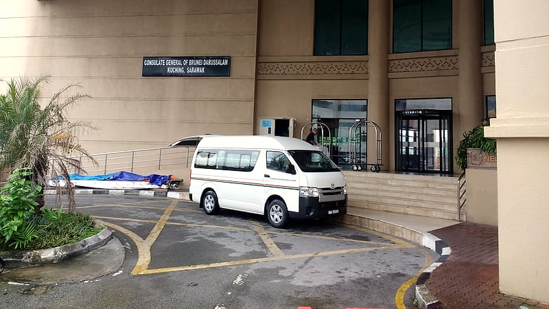 An embossing seal press, an ink pad and a stack of stamped papers arranged on a counter behind protective glass.